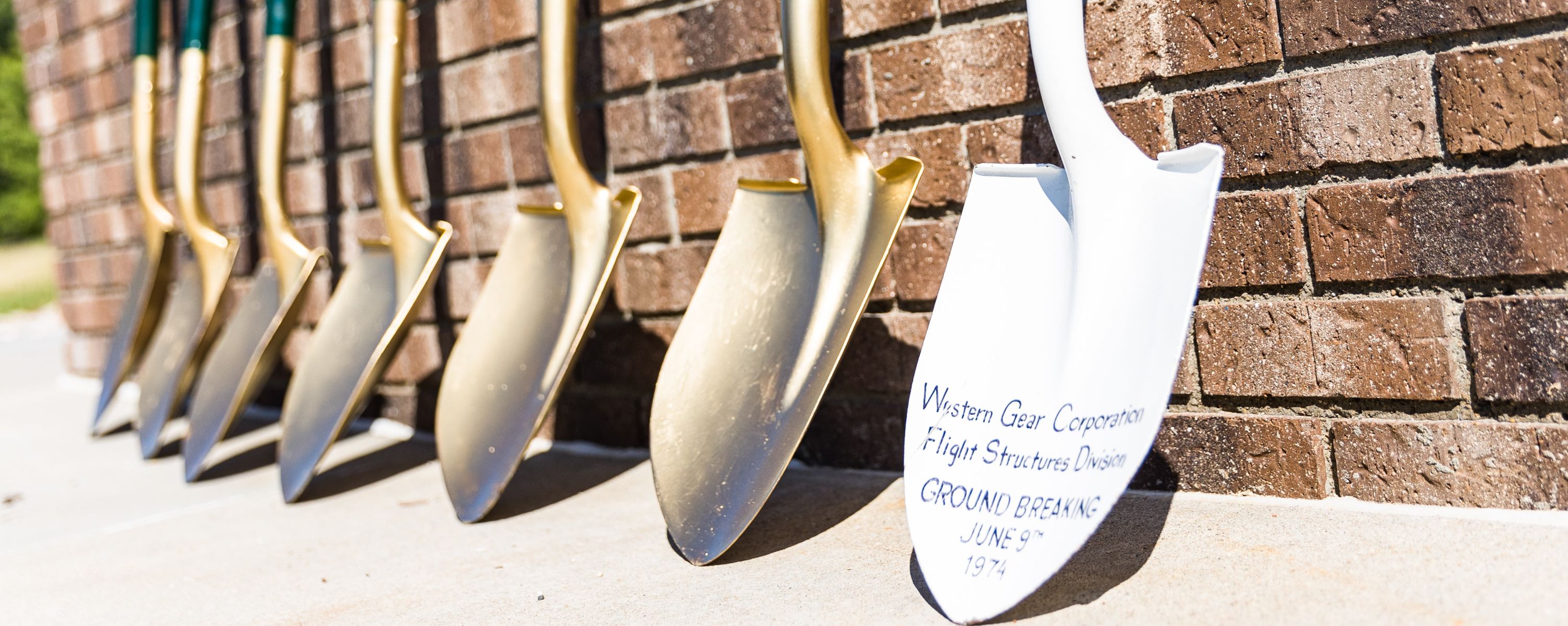 golden shovels against a brick wall